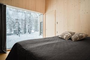 a bedroom with a bed and a large window at Borderlake One in Ruka