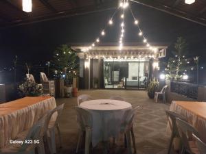 a banquet hall with white tables and chairs and lights at Buddy's Skybar & Suite in Guinsorongan +7 photos