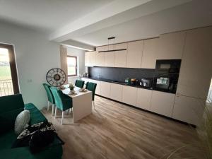 a living room with a table and a kitchen at L&D Apartments in Urseni