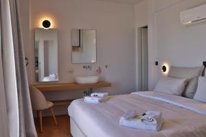 a hotel room with two beds and a sink at 9 Muses Apartments in Agios Nikolaos