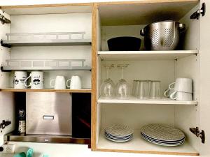 a kitchen pantry with plates and dishes on shelves at Charmant studio aux beaux volumes in Dreux
