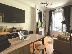 a living room with a table with a laptop on it at Charmant studio aux beaux volumes in Dreux