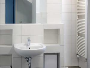 a white bathroom with a sink and a mirror at Appartements am Markt in Greifswald +7 photos