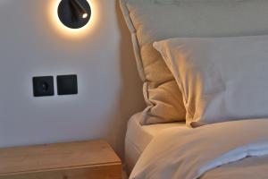 a bed with a pillow and a lamp on a wall at 9 Muses Apartments in Agios Nikolaos