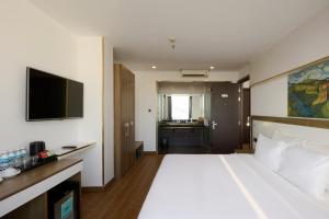 a hotel room with a large bed and a television at The Sol Hotel in Nha Trang