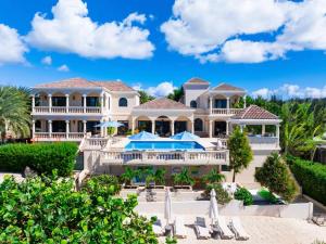 a large white house with a swimming pool and a resort at Sandcastle Villa in Crocus Hill