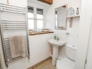 a white bathroom with a toilet and a sink at Sheepwash Barn in Freshwater +34 photos