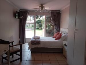 a bedroom with a bed and a ceiling fan at Bloemhoek Guest House in Centurion