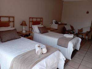 a hotel room with two beds with towels on them at Bloemhoek Guest House in Centurion +7 photos