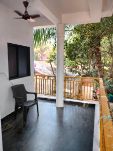 a room with a chair and a television on a porch at Tree hugs mandrem in Mandrem
