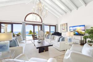 a living room with white furniture and a chandelier at Sandcastle Villa in Crocus Hill