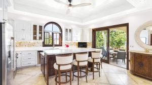 a kitchen with a large island with bar stools at Sandcastle Villa in Crocus Hill
