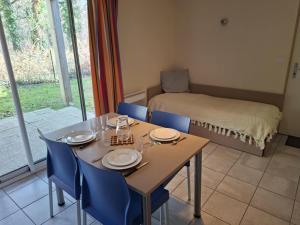 a dining room with a table and chairs and a bed at Cottage Le Vau 3, RDC calme, lave linge, piscine in Chaveignes
