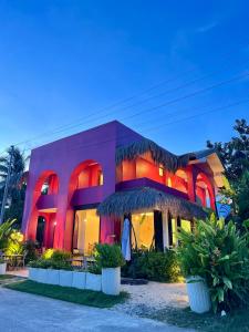 a pink building with red lights on it at BIG WAVES BOUTIQUE HOTEL SIARGAO in General Luna