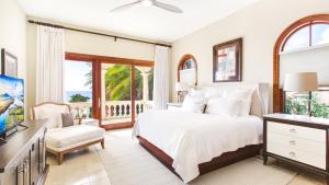 a bedroom with a white bed and a balcony at Sandcastle Villa in Crocus Hill +65 photos