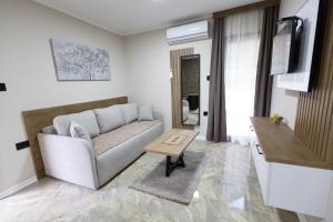 ein Wohnzimmer mit Sofa und Tisch in der Unterkunft Vila Sofija Banja Vrujci in Gornja Toplica