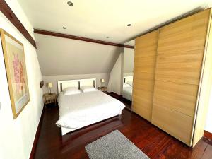 a bedroom with a bed and a large wooden closet at Jolie chambre sous les toits in Dreux +65 photos