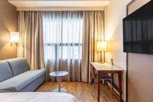 a hotel room with a couch and a table at Scandic Postitalo in Tampere