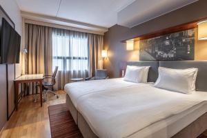 a hotel room with a large bed and a desk at Scandic Postitalo in Tampere