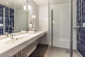a bathroom with a sink and a shower at Scandic Postitalo in Tampere +24 photos