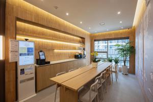 a kitchen with a long wooden table and chairs at Haeundae Marine Capsule Hotel&Spa in Busan