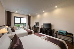 a hotel room with two beds and a television at Adonis Hotel in Hanoi +35 photos