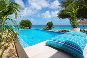 a swimming pool in front of the ocean at Sandcastle Beach House in The Valley