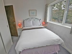 a bedroom with a large bed with a window at Ken Maree in South Erradale