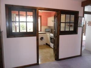 a kitchen with a door open to a kitchen with a microwave at Ken Maree in South Erradale +6 photos