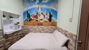 a small room with a bed with a painting on the wall at 清境77窩House-包棟包層民宿 in Ren'ai