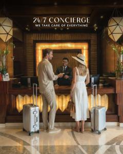 a man and a woman standing with suitcases in a lobby at El Safwa Resort New Cairo in Cairo +66 photos