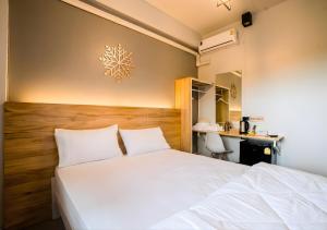 a bedroom with a white bed and a desk at Royce Boutique Betong in Betong