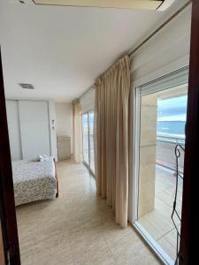 a bedroom with a bed and a sliding glass door at Pineda Beach PORT AVENTURA in La Pineda