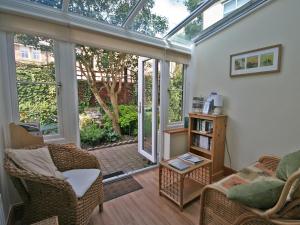 a living room with a conservatory with glass doors at Cosy Cottage in Warkworth +8 photos