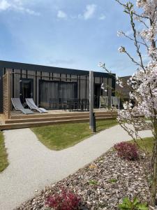 a modern house with a black facade and a garden at The Originals City, Ax Hotel, La Châtaigneraie in La Châtaigneraie