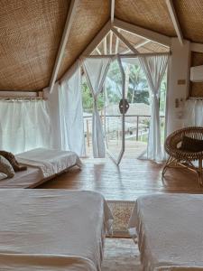 a bedroom with two beds and a large window at Punta Punta Surf Retreat in General Luna +44 photos