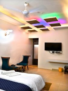a bedroom with a bed and a flat screen tv at Hotel Rainbow in Yamunānagar