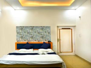 a bedroom with a large bed with blue pillows at Hotel Rainbow in Yamunānagar