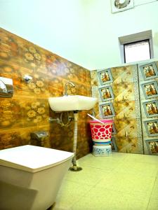 a bathroom with a sink and a tub and a toilet at Hotel Rainbow in Yamunānagar +19 photos
