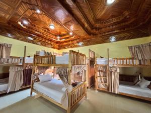 a room with four bunk beds and a ceiling with beams at Nongkhiew Heaven Backpackers Hostel & Tours in Nongkhiaw