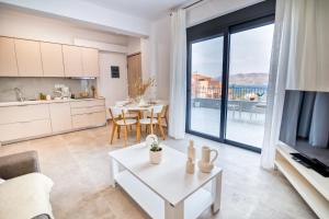 a kitchen and living room with a table and a view at Maison Poème Luxury Apartments in Aiándion