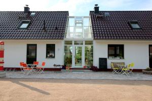 a house with chairs and tables in front of it at Ostseepension TonArt in Mechelsdorf