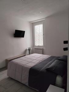 a bedroom with a bed and a television on the wall at Ca' de' Mari at Como - Switzerland - Private Parking - Self Check-In in Faloppio