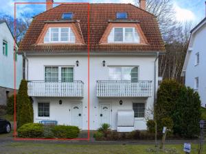 a white house with two windows and a roof at Fährhaus Sellin - Ferienwohnung 2 in Ostseebad Sellin