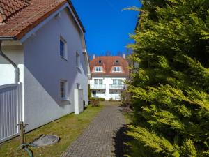 a cobblestone alley between two white buildings with trees at Fährhaus Sellin - Ferienwohnung 2 in Ostseebad Sellin