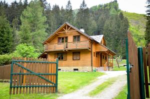 a wooden house with a gate in front of it at Wili Hunter in Donovaly