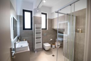 a bathroom with a toilet and a sink and a shower at Maison Poème Luxury Apartments in Aiándion