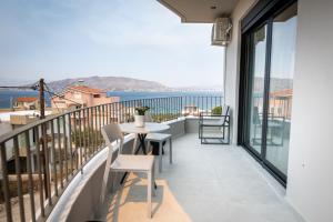 a balcony with a table and chairs and a view of the water at Maison Poème Luxury Apartments in Aiándion +16 photos