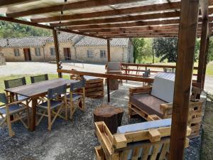 a picnic table and chairs under a wooden pavilion at Tipico casolare toscano Tenuta della Selva in Murlo