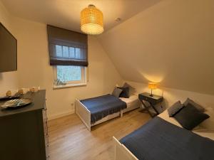 a small room with two beds and a window at Villa Strandleben in Zingst